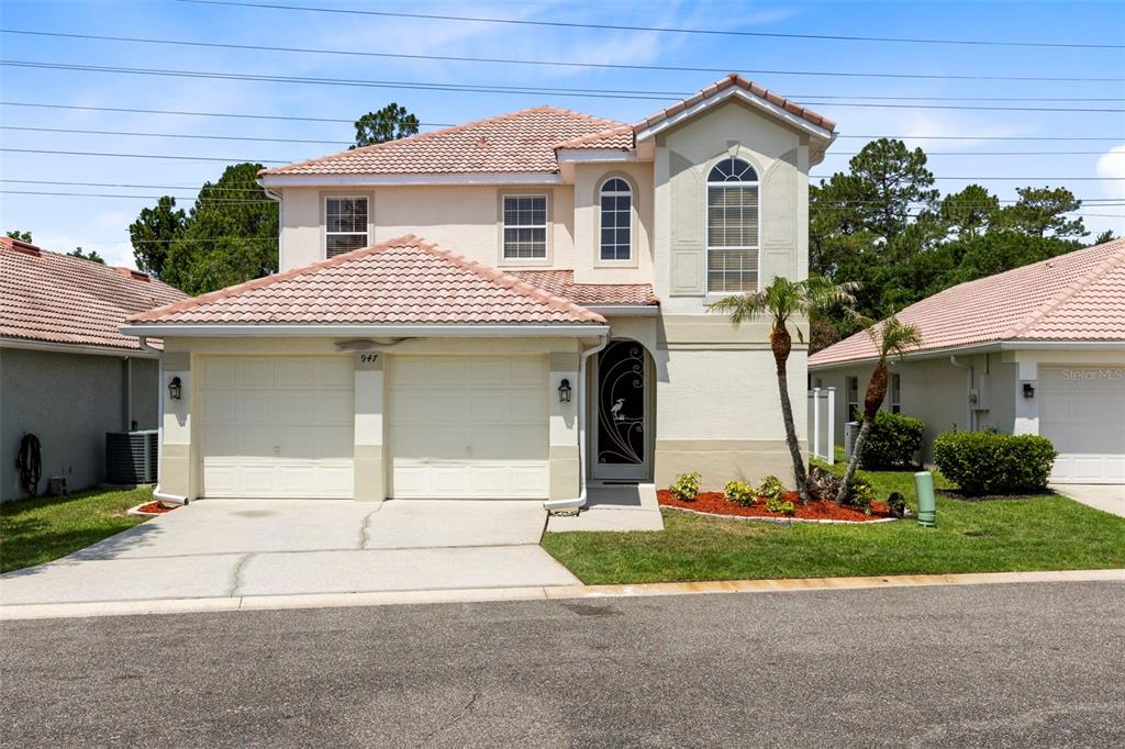 A two-story house with a tiled roof, a two-car garage, and a decorative front door — 947 GLEN ABBEY CIRCLE, WINTER SPRINGS, FL