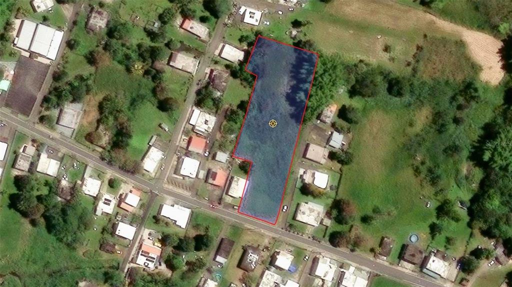 An aerial view shows a rectangular plot of land outlined in red in a neighborhood — BO CEIBA NORTE 28 COM SANTANA, JUNCOS, PR
