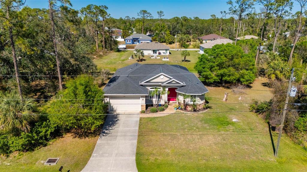 An aerial view of a single-story house with a dark roof and a concrete driveway — 4462 LA FRANCE AVENUE, NORTH PORT, FL