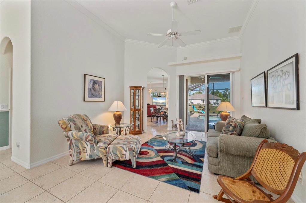 A living room with tile floors, a colorful area rug, and a sliding glass door — 4462 LA FRANCE AVENUE, NORTH PORT, FL