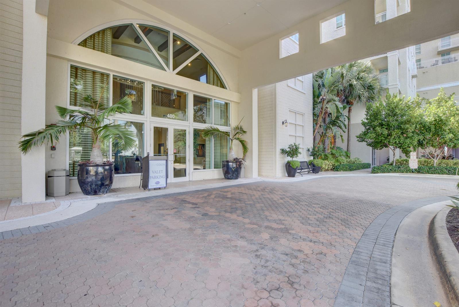 A paved driveway leads to the arched glass entrance of a multi-story building with palm trees — 450 N Federal Highway # 504, Boynton Beach FL 33435, BOYNTON BEACH, FL