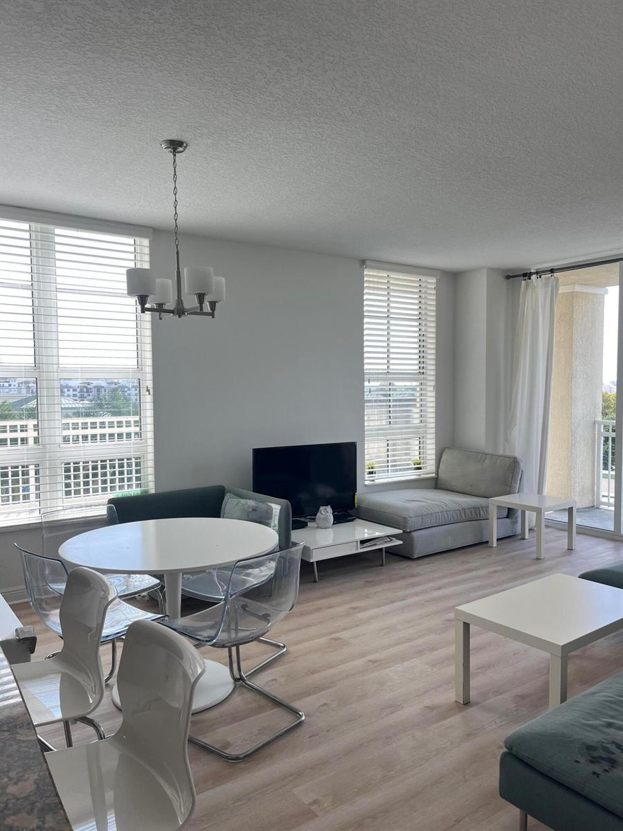 A bright living and dining area features light wood floors, large windows, and modern furniture — 450 N Federal Highway # 504, Boynton Beach FL 33435, BOYNTON BEACH, FL