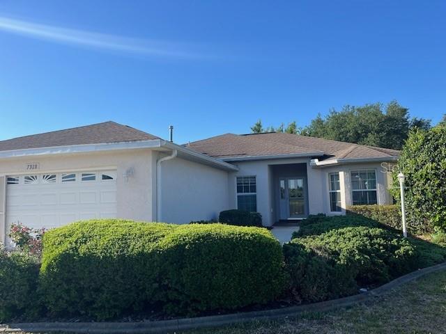 A single-story house with a white exterior, a two-car garage, and large green bushes — 7928 SW 80TH PLACE ROAD, OCALA, FL
