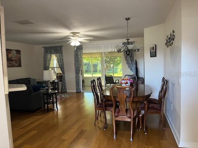 A dining area with a wooden table and chairs sits adjacent to a living room — 7928 SW 80TH PLACE ROAD, OCALA, FL