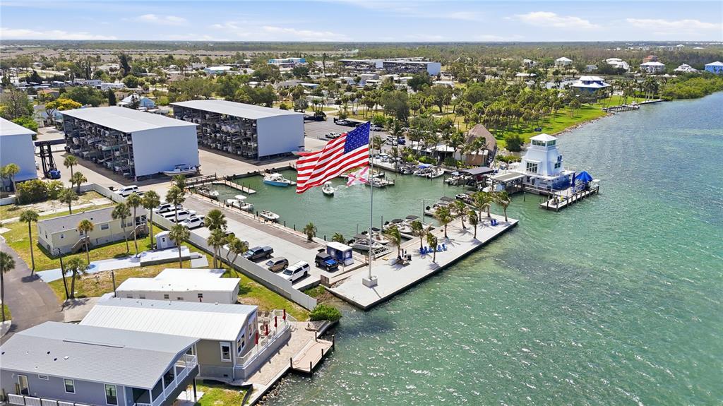 An aerial view shows a marina with boat storage, a dock, and several waterfront homes — 3161 BOURBON STREET, ENGLEWOOD, FL