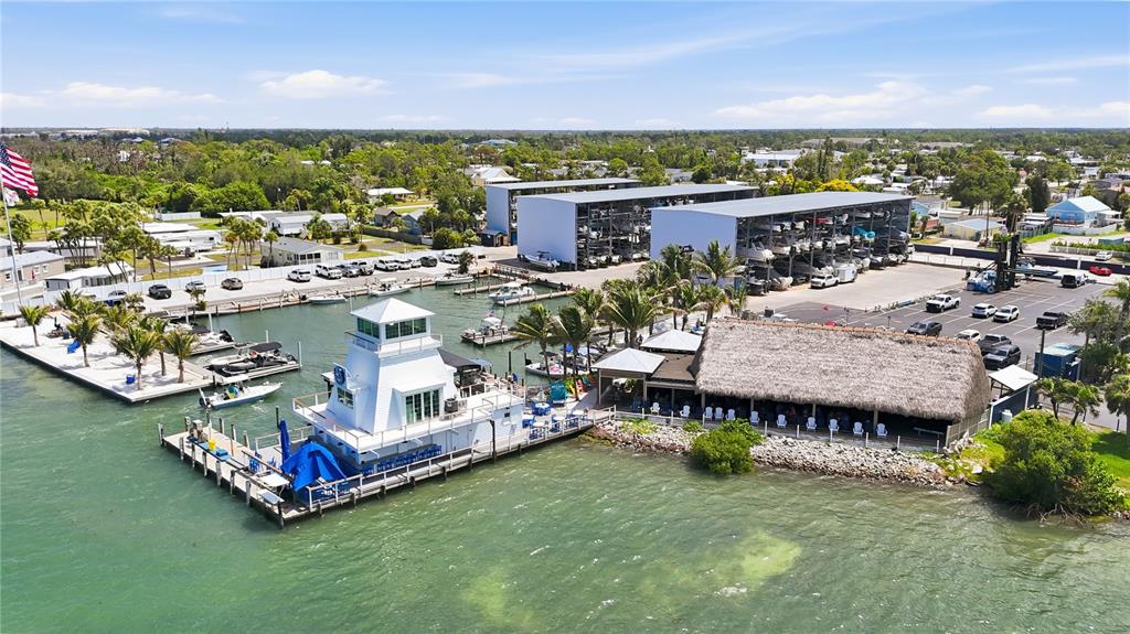 An aerial view shows a marina with a lighthouse-style building, boat storage racks, and parking — 3161 BOURBON STREET, ENGLEWOOD, FL