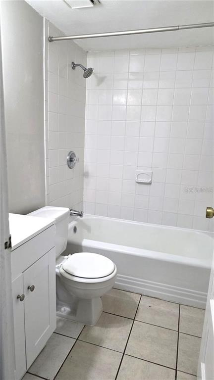 A bathroom features a white vanity, a toilet, and a shower-tub combo with white tiles — 1113 S PARK AVENUE, SANFORD, FL