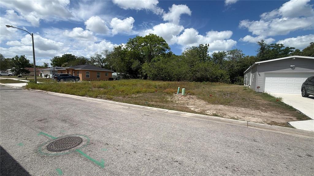 A vacant residential lot sits between two houses along a paved street — 15579 CHARMWOOD DRIVE, HUDSON, FL