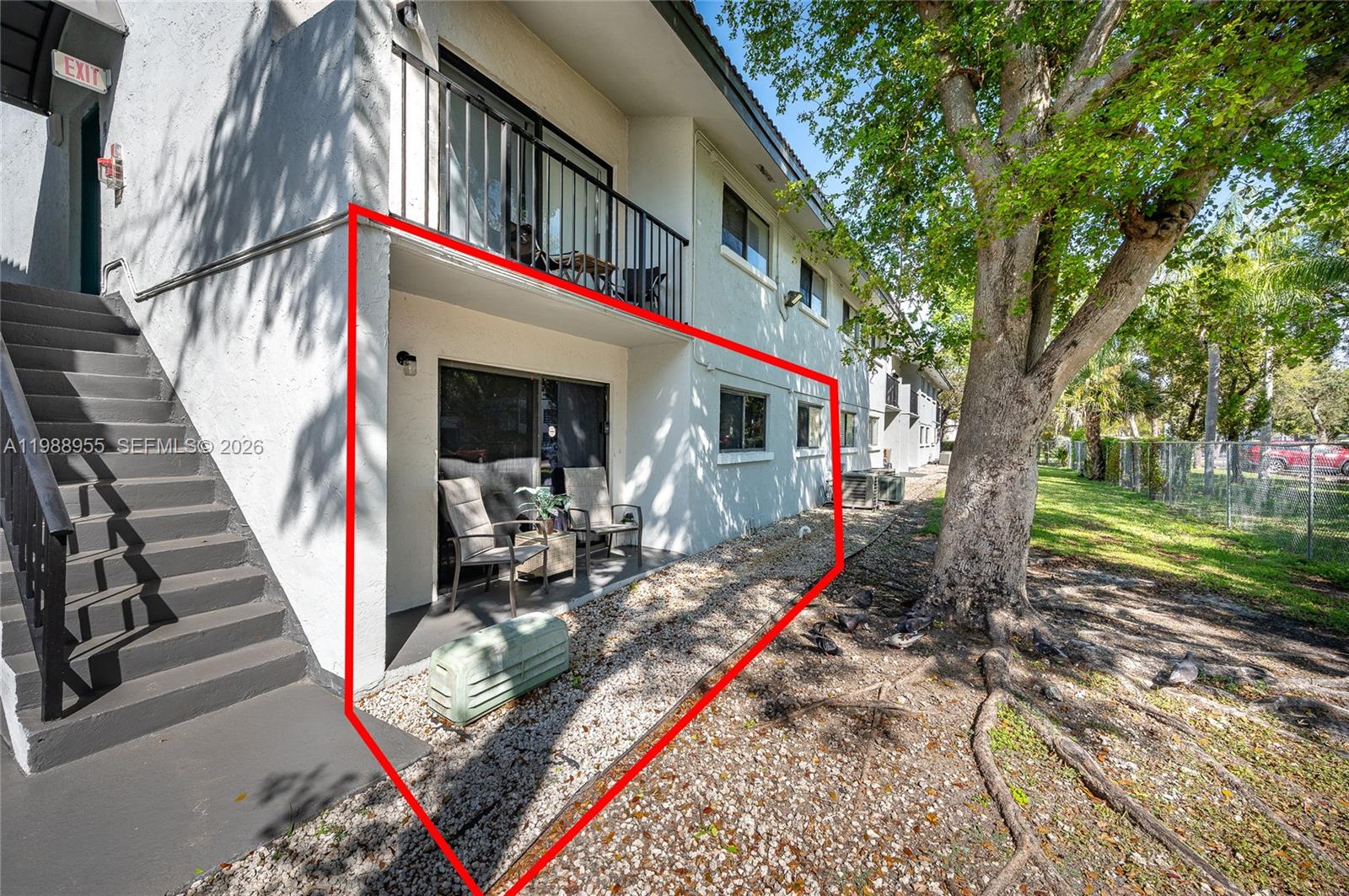 The exterior of a ground-floor apartment unit features a patio, sliding glass doors, and stairs — 7095 NW 179th St # 110, Hialeah FL 33015, HIALEAH, FL