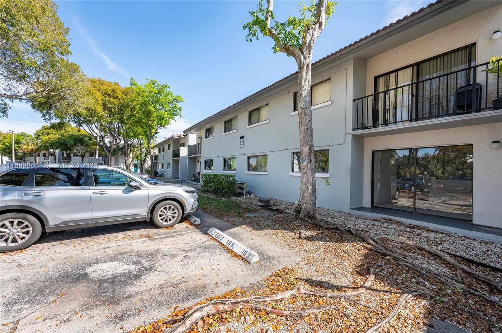 A silver SUV is parked in front of a two-story apartment building with exterior balconies — 7095 NW 179th St # 110, Hialeah FL 33015, HIALEAH, FL