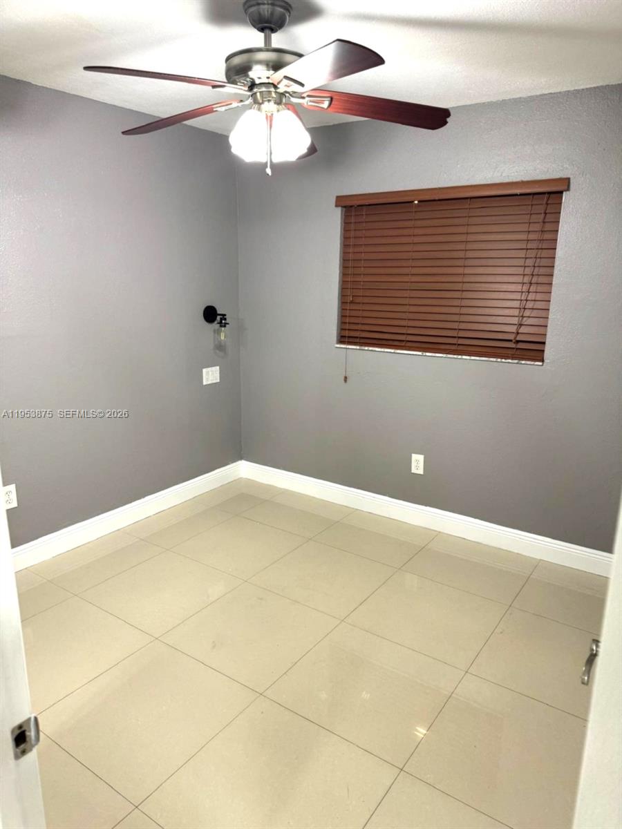 This room features gray walls, large light-colored floor tiles, and a ceiling fan — 5461 W 24th Ave # 25, Hialeah FL 33016, HIALEAH, FL