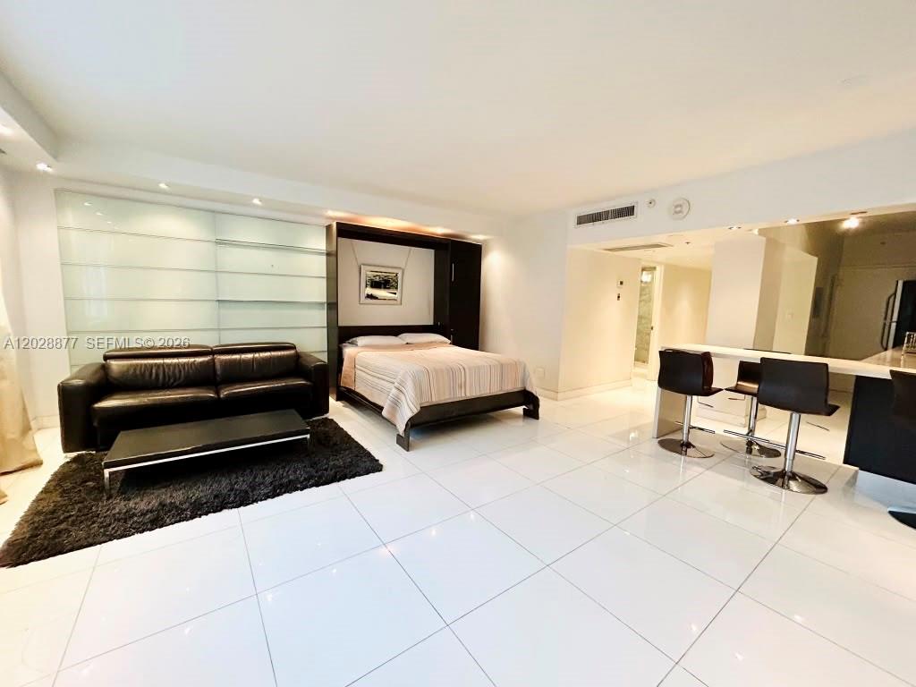 A studio apartment features a black leather sofa, a Murphy bed, and a breakfast bar — 100 Lincoln Rd # 701, Miami Beach FL 33139, MIAMI BEACH, FL