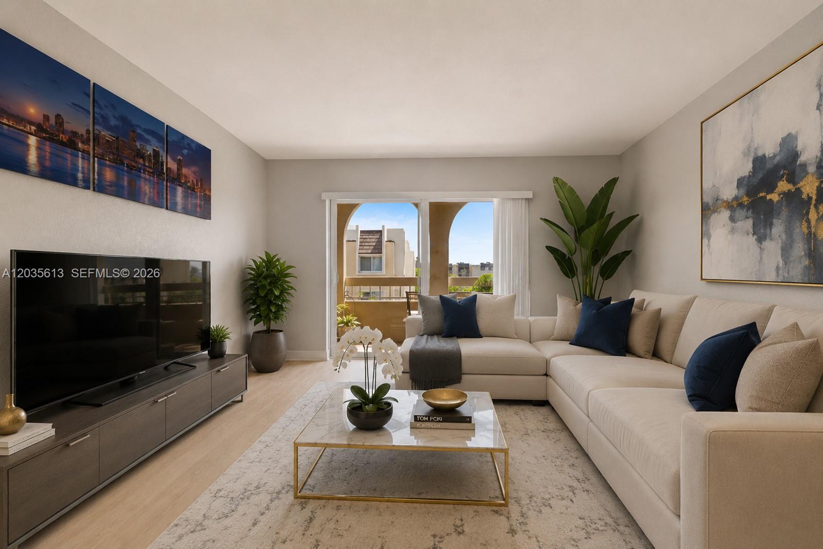 A living room features a sectional sofa, a marble coffee table, and a television console — 7845 Camino Real # 413, Miami FL 33143, MIAMI, FL