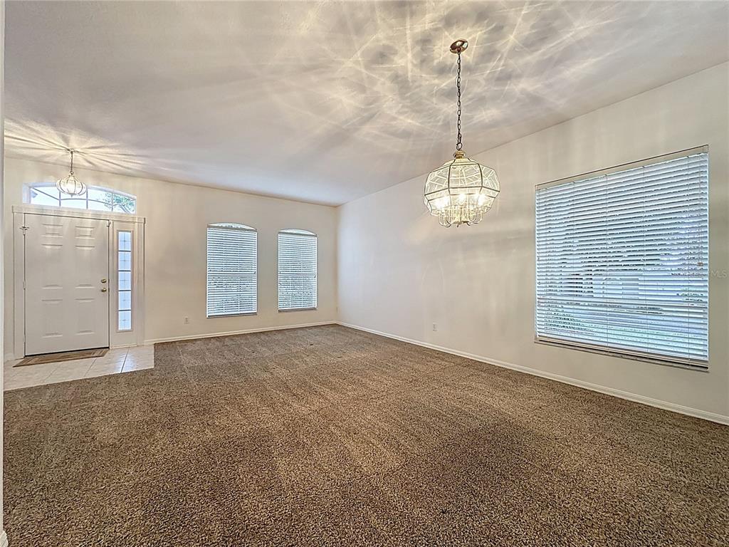 A living room features a white sofa, two armchairs, a coffee table, and two windows — 4246 NEWLAND STREET, CLERMONT, FL