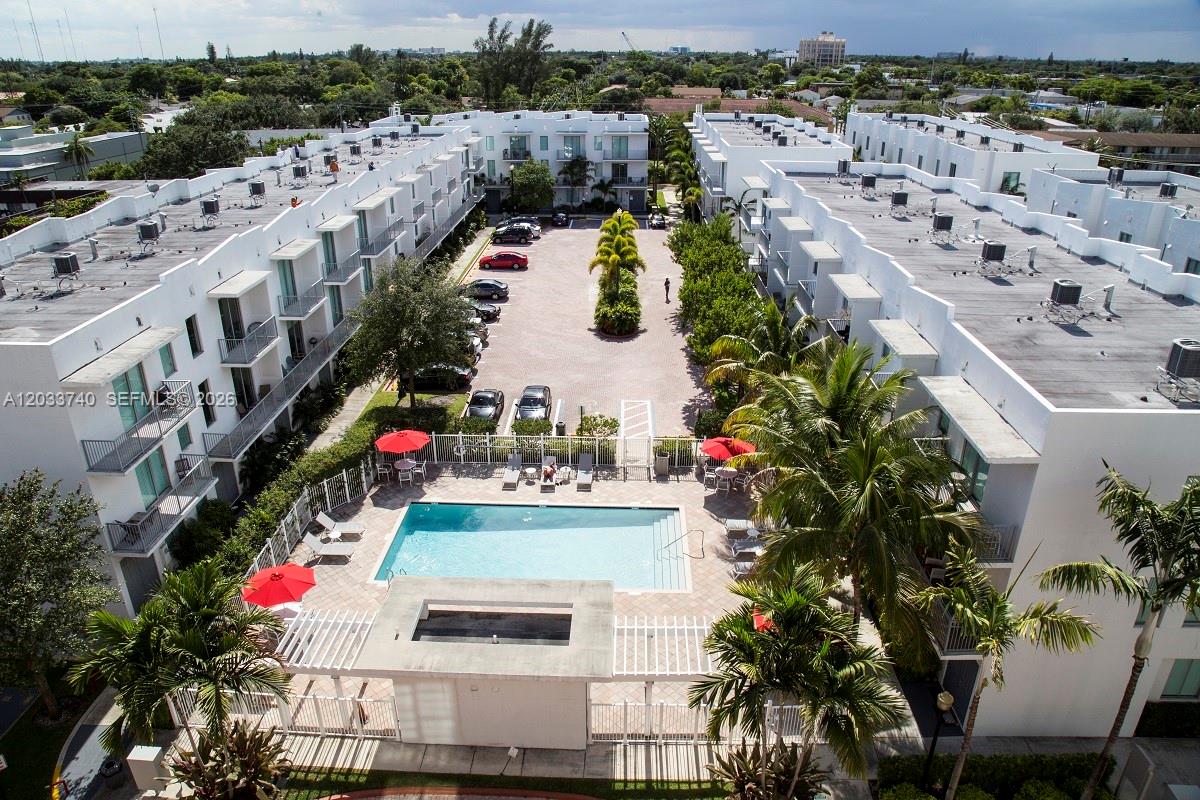 An aerial view shows a residential complex with a central swimming pool and parking lot — 2100 Van Buren St # 322, Hollywood FL 33020, HOLLYWOOD, FL