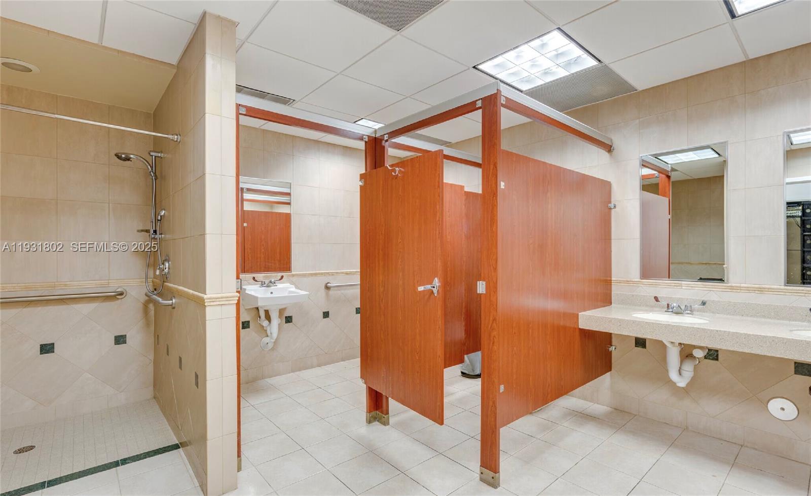 A commercial restroom features a shower stall, two sinks, and a wooden toilet partition — 6900 SW 80th St, Miami FL 33143, MIAMI, FL