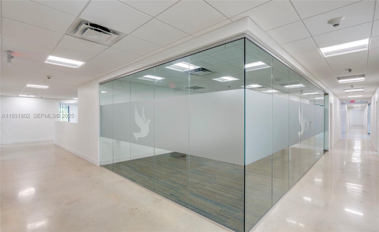 An office interior features a glass-walled conference room with frosted privacy film and carpet flooring — 6900 SW 80th St, Miami FL 33143, MIAMI, FL