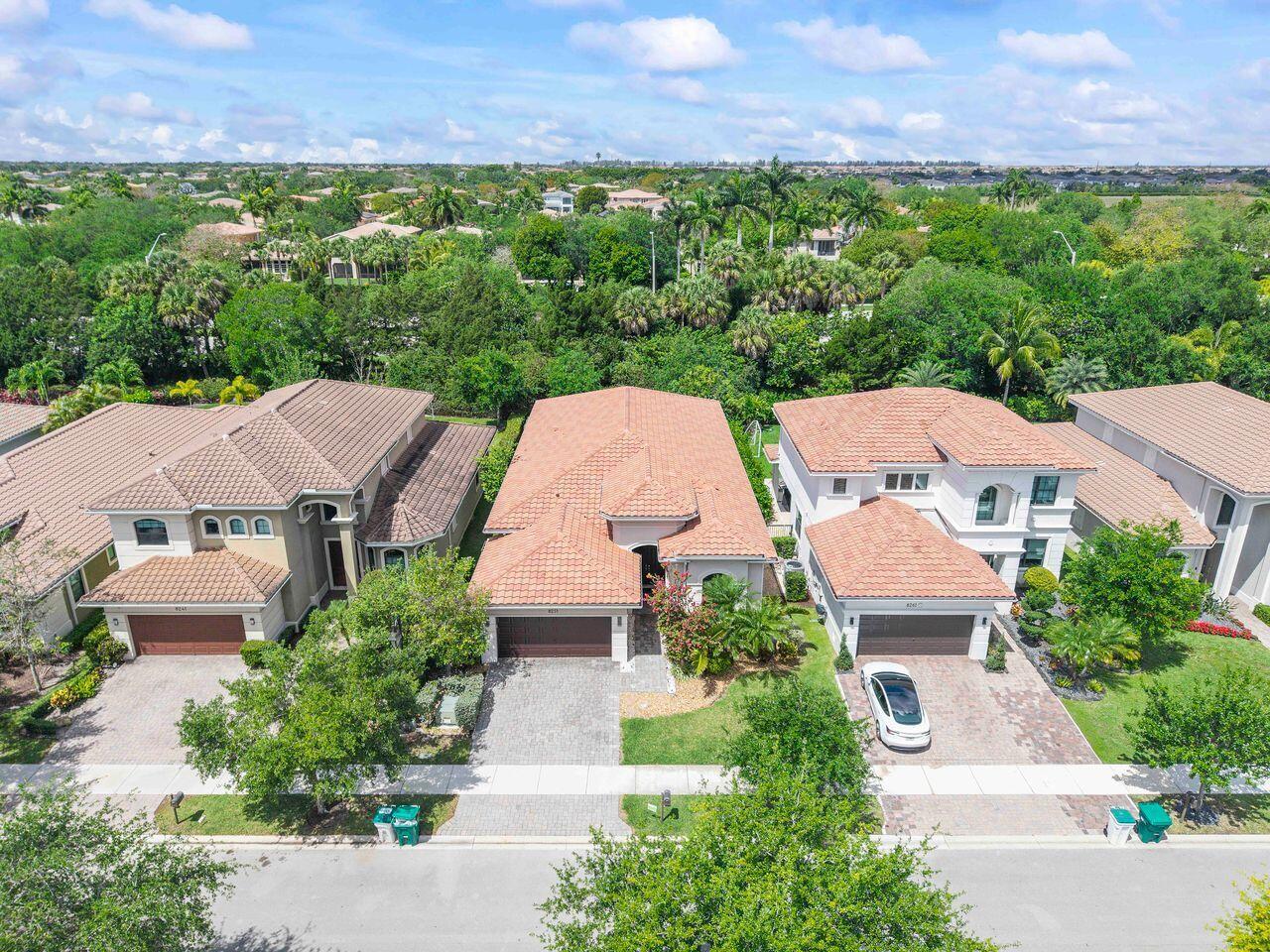 An aerial view shows three suburban houses with tiled roofs and paved driveways — 8251 Canopy Terrace, Parkland FL 33076, PARKLAND, FL