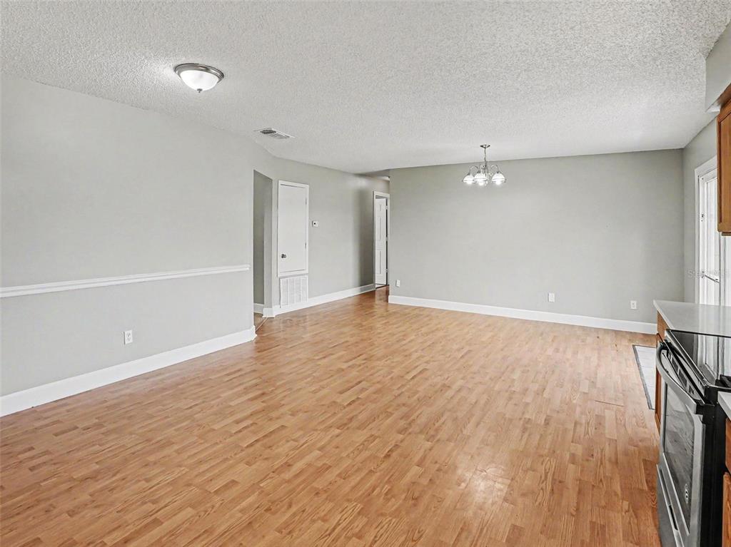 An empty room with light gray walls, wood-look flooring, and a white ceiling fixture — 510 MOONBEAM ROAD, APOPKA, FL