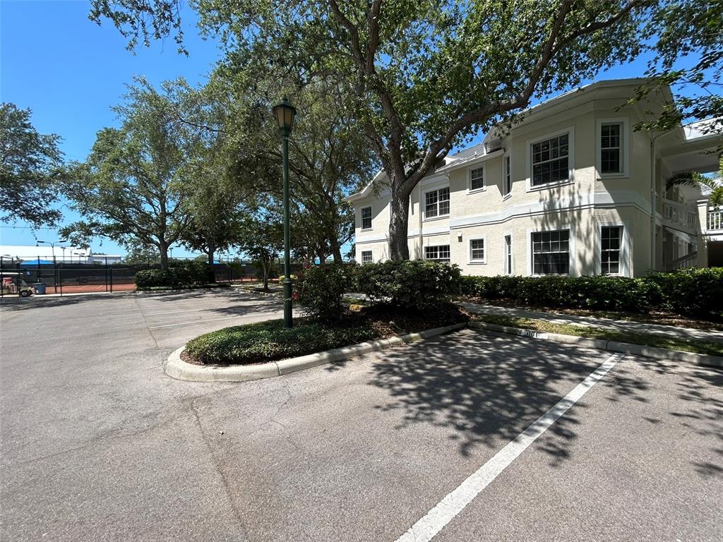 A multi-story building with a parking lot and a lamppost in the foreground — 3702 54TH DRIVE W UNIT 204, BRADENTON, FL
