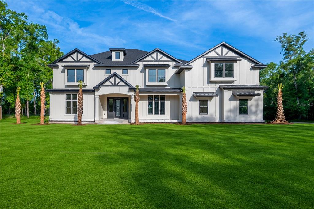 A two-story modern farmhouse with white board-and-batten siding and a dark shingled roof — 285 SW HERMITAGE GLEN, HIGH SPRINGS, FL
