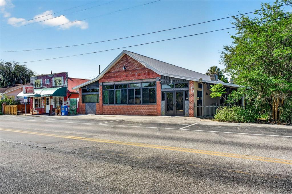 A red brick commercial building with large windows sits next to a smaller restaurant — 32750 PENNSYLVANIA AVENUE, SAN ANTONIO, FL
