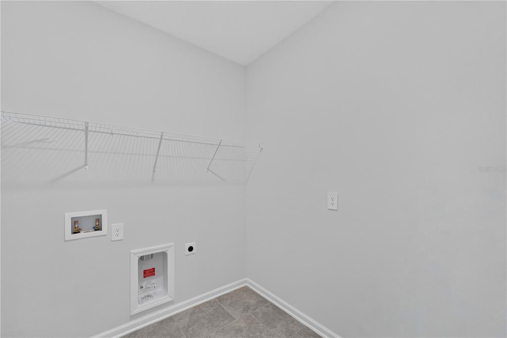 A kitchen with white cabinets and a gray island opens into a dining area — 6430 PINE WARBLER, ST CLOUD, FL