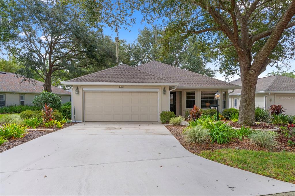 A single-story house with a beige exterior, a two-car garage, and a concrete driveway — 6482 W TORRINGTON COURT, CRYSTAL RIVER, FL