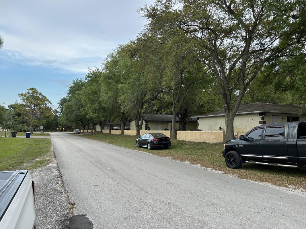 A street view shows a row of single-story houses with parked cars and mature trees — 801 King Orange Drive, Fort Pierce FL 34982, FORT PIERCE, FL