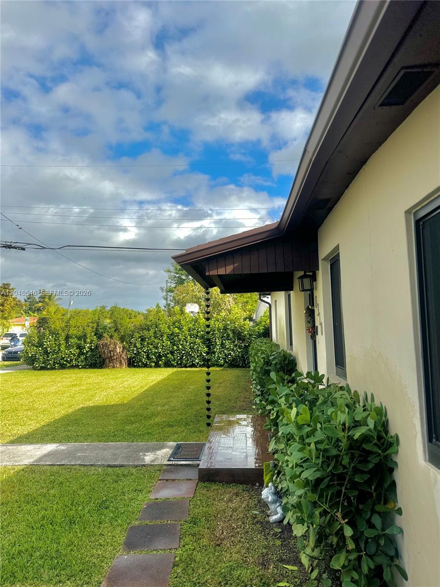 A side view of a house exterior features a lawn, a walkway, and a rain chain — 8310 SW 37th St # 0, Miami FL 33155, MIAMI, FL
