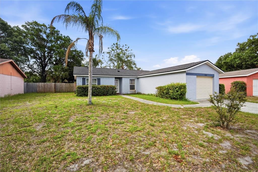 A single-story house with a light blue exterior, a garage, and a palm tree — 11505 PAPERWOOD PLACE, RIVERVIEW, FL