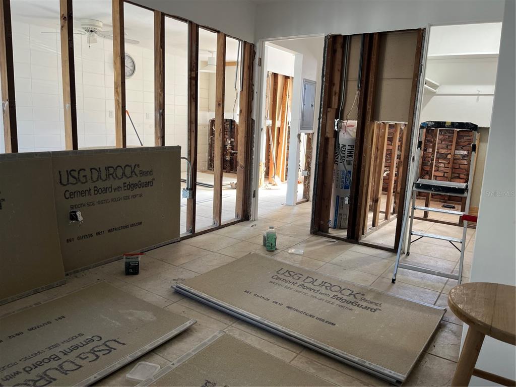 A room under renovation features exposed wall studs, cement board panels, and tiled flooring — 701 SAINT JUDES DRIVE S UNIT 3, LONGBOAT KEY, FL