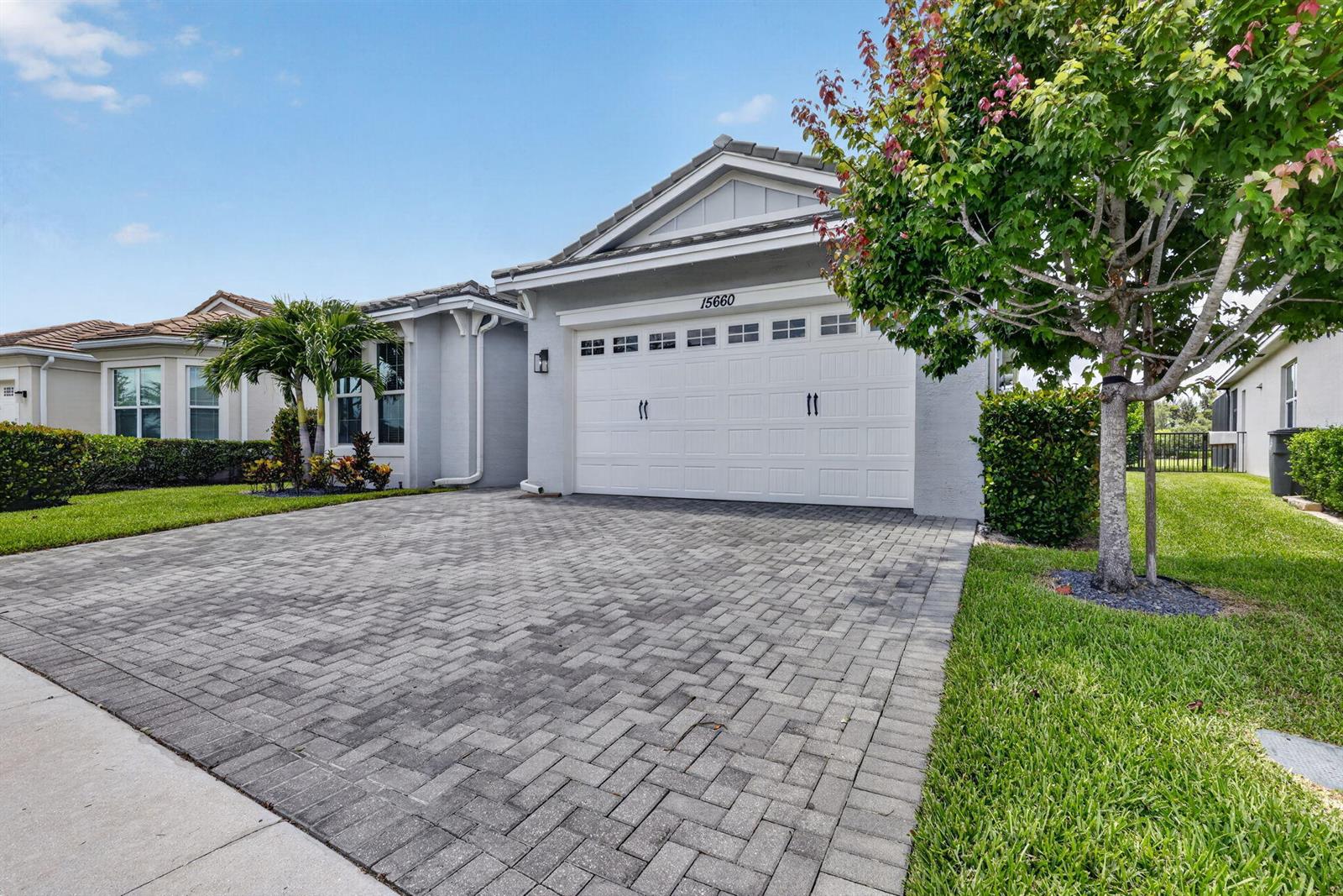 A single-story house with a paved driveway, a two-car garage, and a front yard — 15660 Goldfinch Circle, FL 33470, FL