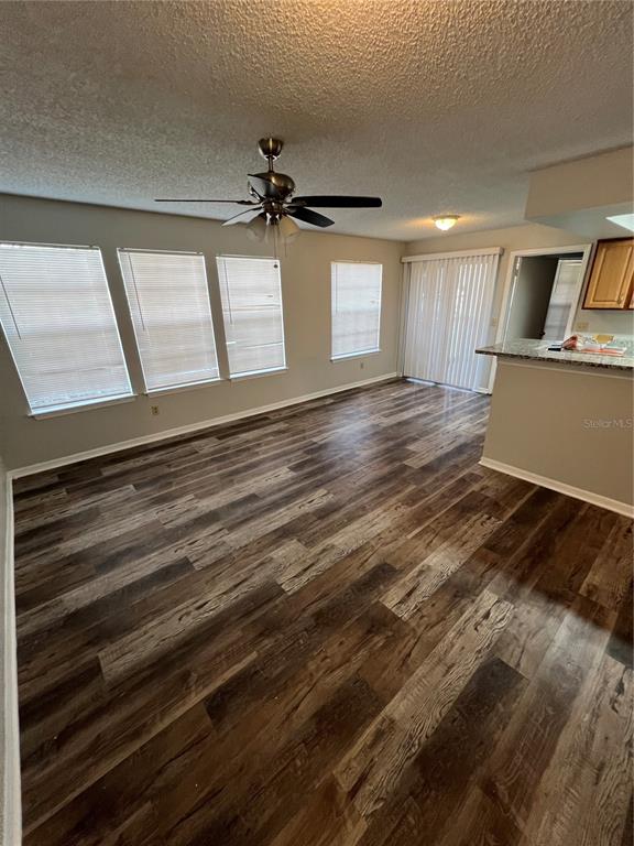 A dining area features wood-look flooring, a ceiling fan, multiple windows, and a sliding glass door — 1027 S HIAWASSEE ROAD UNIT 2313, ORLANDO, FL