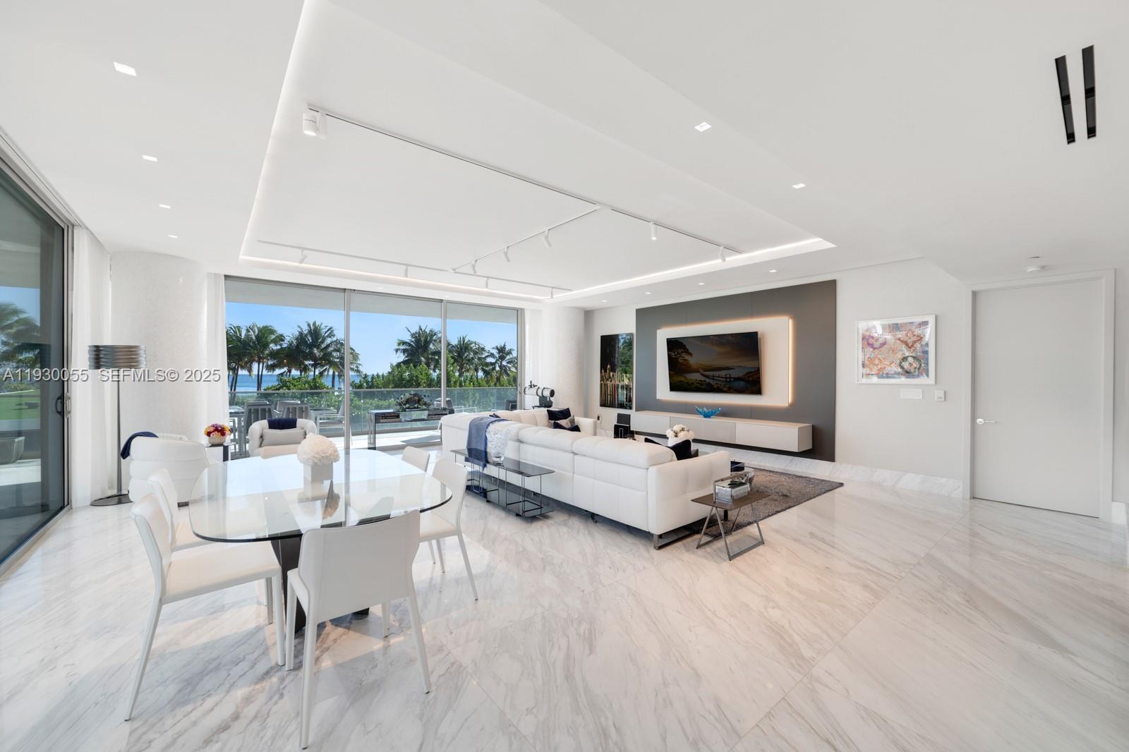 A modern living and dining area features marble floors, white furniture, and floor-to-ceiling windows — 10203 Collins Ave # 201, Bal Harbour FL 33154, BAL HARBOUR, FL