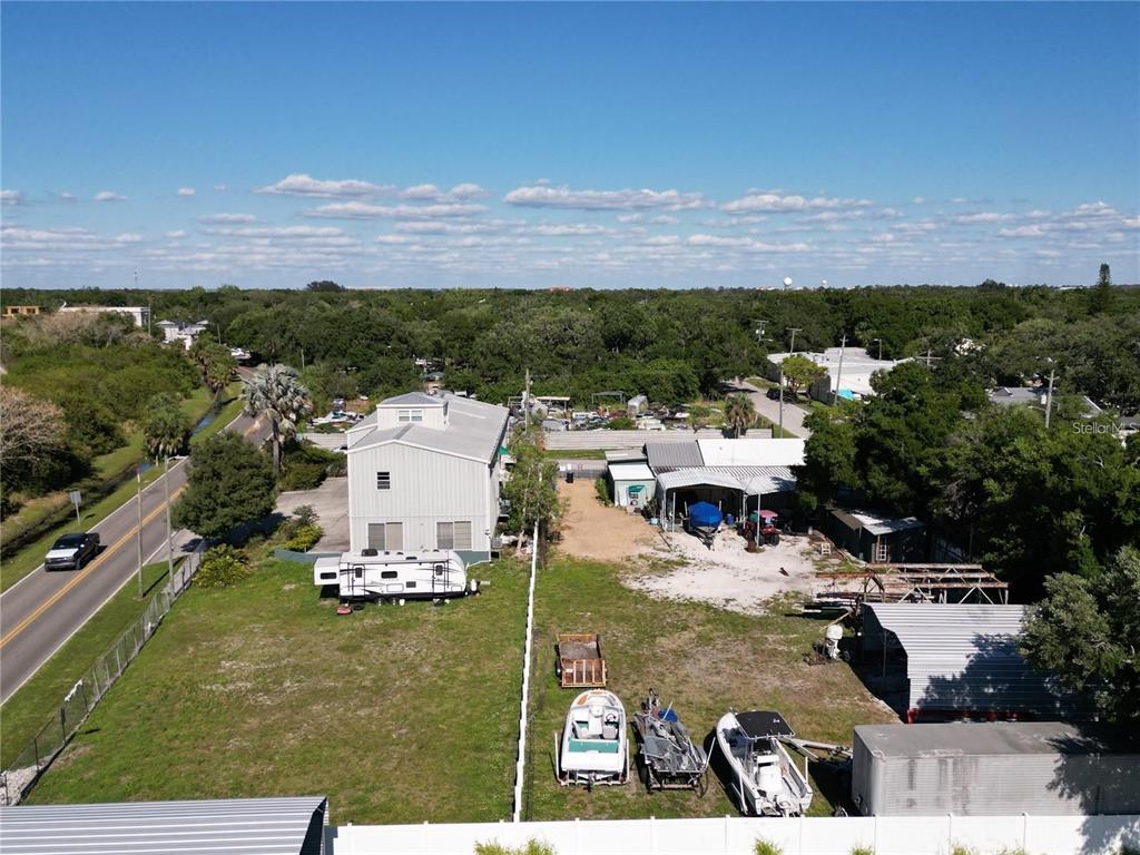 An aerial view shows a large lot with a multi-story building, RV, boats, and outbuildings — 5101 W INGRAHAM STREET, TAMPA, FL