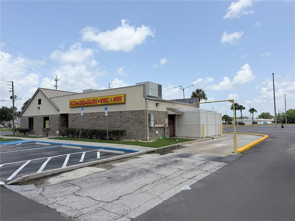 A brick commercial building with a drive-thru lane and a sign advertising food — 2439 ENTERPRISE ROAD, ORANGE CITY, FL