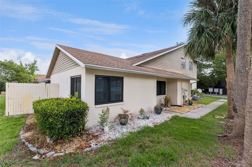 The exterior of a beige, two-story residential building with a shingled roof and landscaping — 668 OLYMPIC DRIVE UNIT 1, OCOEE, FL