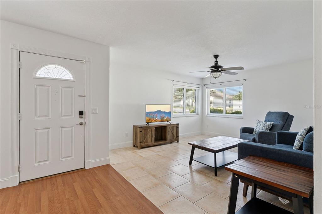 A living room features tile flooring, a ceiling fan, and a front door entrance — 668 OLYMPIC DRIVE UNIT 1, OCOEE, FL