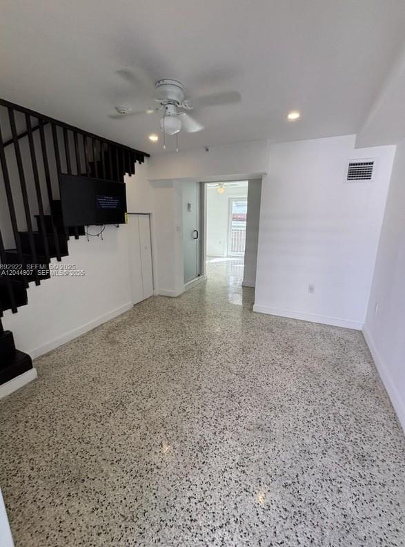 A room with speckled flooring, a black staircase, a ceiling fan, and a glass doorway — 560 NW 1st St # 7, Miami FL 33128, MIAMI, FL
