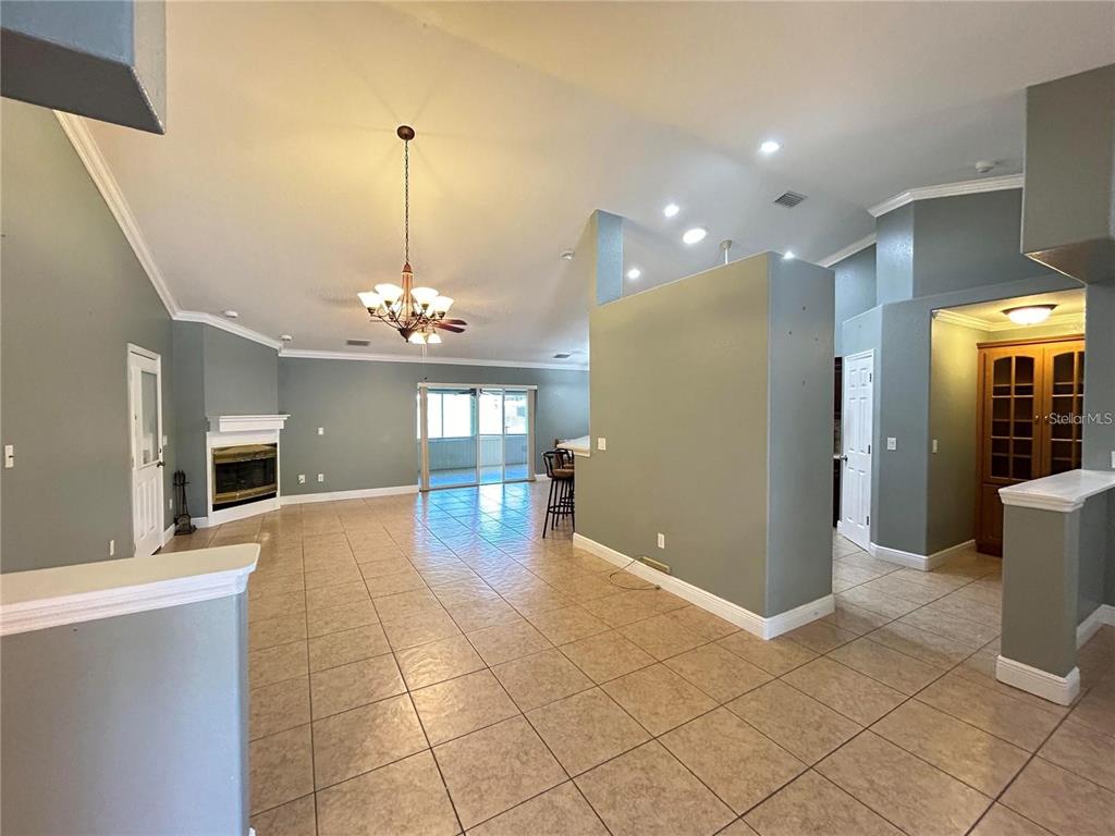 A living room with tile flooring, a corner fireplace, and a vaulted ceiling — 1921 FLOWER TERRACE, SEBRING, FL