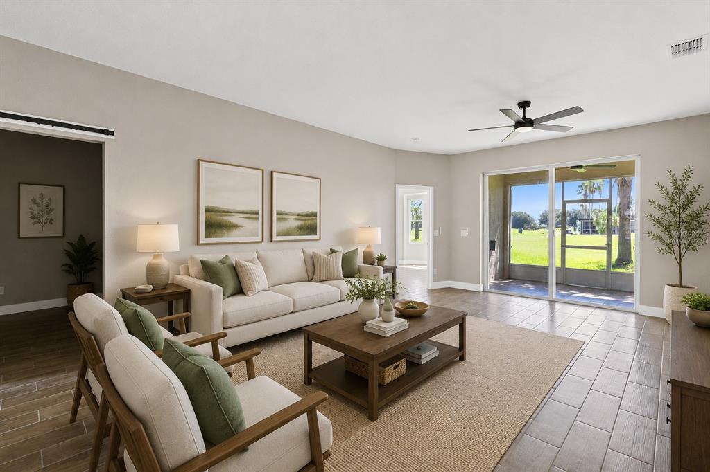 A living room features a sofa, two armchairs, a coffee table, and sliding glass doors — 183 CLUB VILLAS LANE, KISSIMMEE, FL