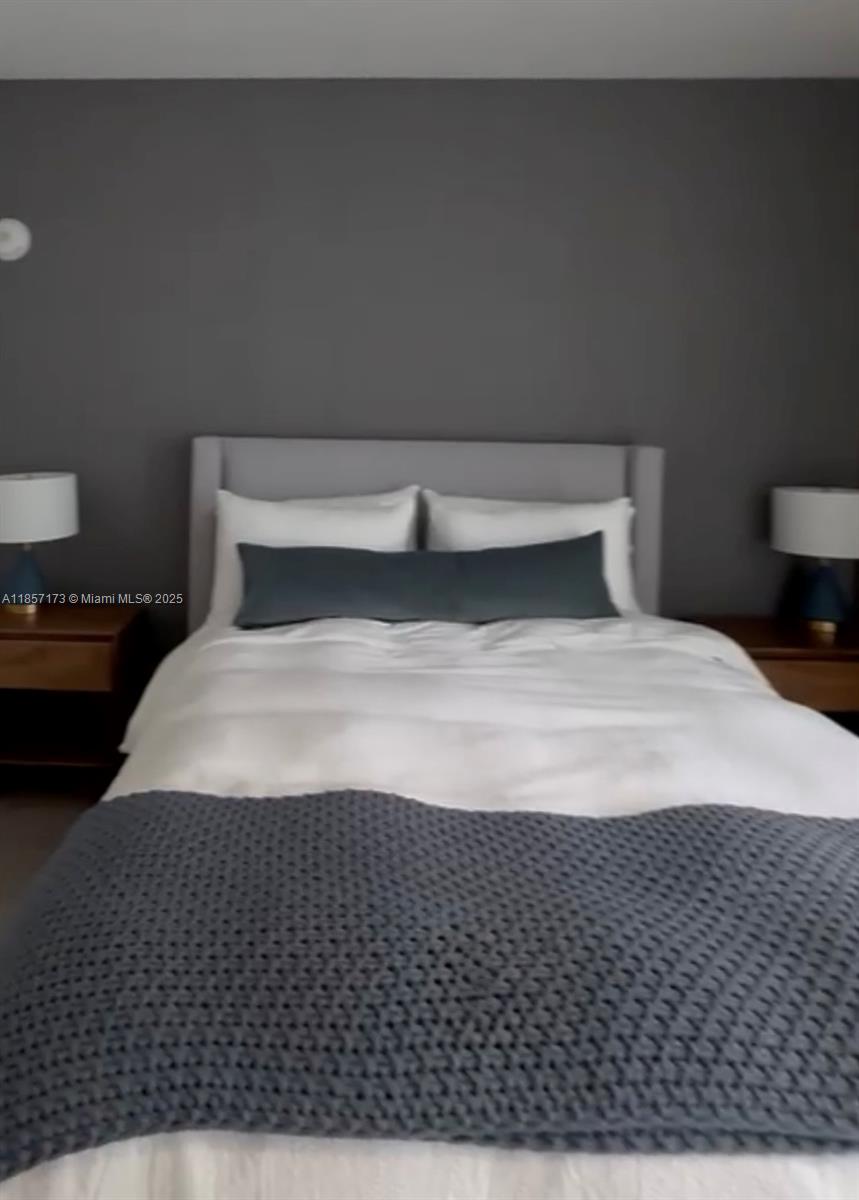 A bedroom features a gray accent wall, a white bed with gray bedding, and two nightstands — 229 SW 9th St # 403, Miami FL 33130, MIAMI, FL