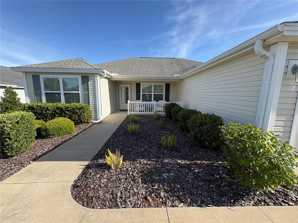 A single-story house with beige siding, a concrete walkway, and a landscaped front yard — 3135 BURNS DRIVE, THE VILLAGES, FL
