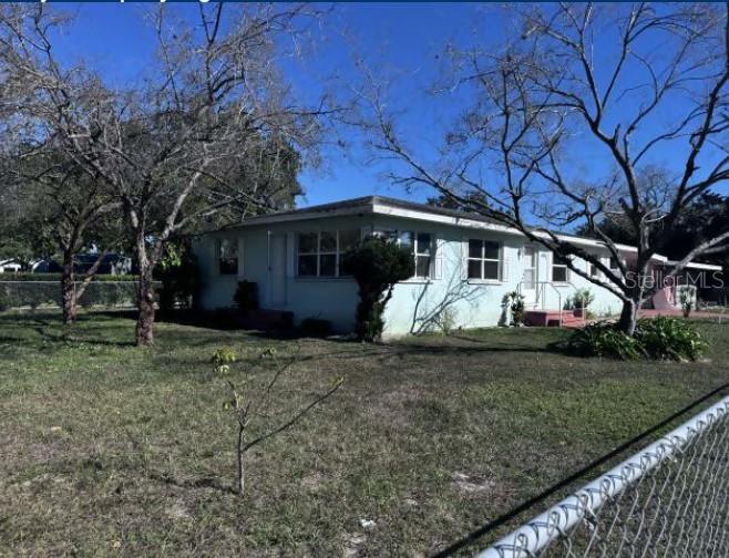 A light blue, single-story house with a flat roof sits on a grassy lot — 321 ARIANA AVENUE, AUBURNDALE, FL