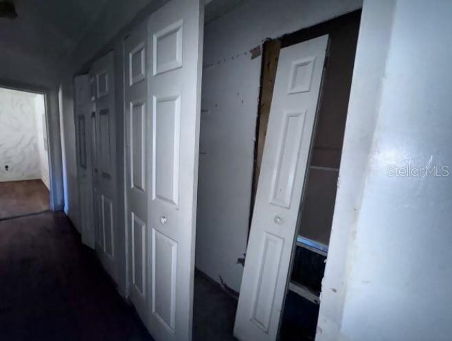 A hallway features a series of white bifold closet doors, one of which is partially detached — 321 ARIANA AVENUE, AUBURNDALE, FL