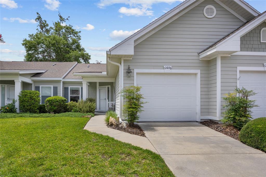 A light-colored single-story house exterior with a garage, a concrete driveway, and a front walkway — 12656 NW 11TH PLACE, NEWBERRY, FL