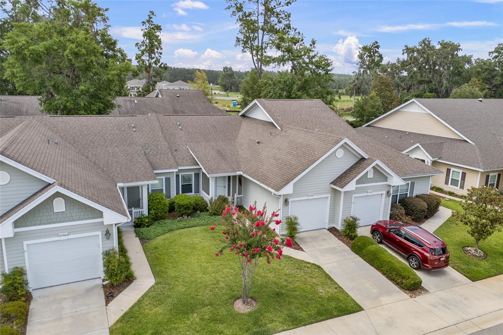 An aerial view shows two attached single-story houses with light siding, shingled roofs, and garages — 12656 NW 11TH PLACE, NEWBERRY, FL