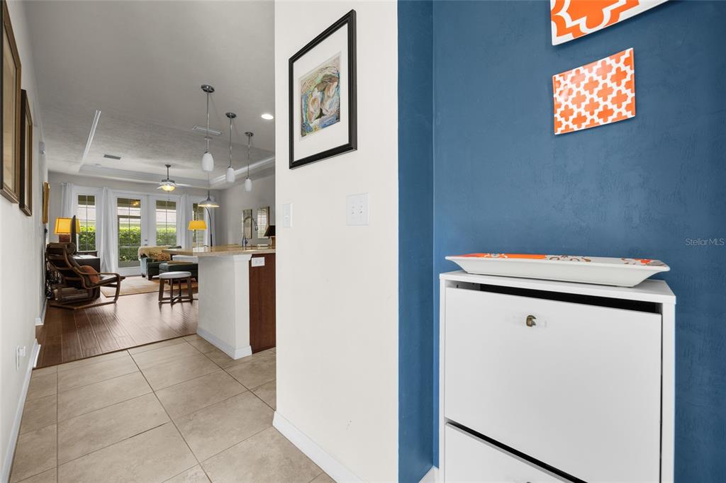 A tiled entryway leads into a living area with wood flooring and a kitchen island — 12656 NW 11TH PLACE, NEWBERRY, FL