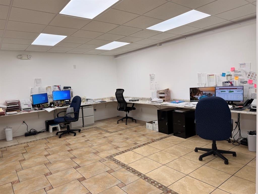 An office space features tiled floors, a long built-in desk, and three computer workstations — 7117 N ARMENIA AVENUE, TAMPA, FL